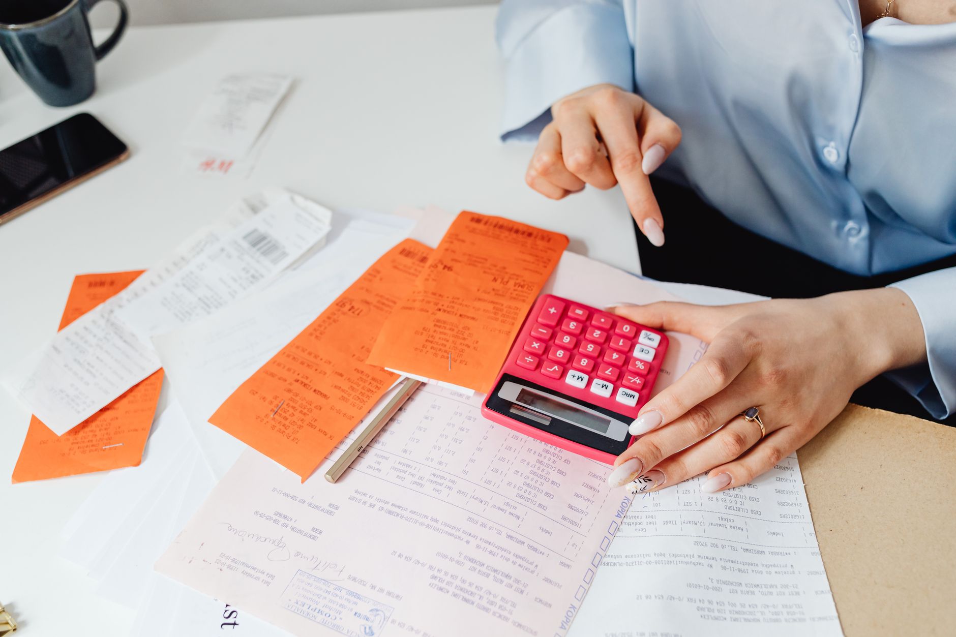 a calculator on a desk beside paper receipts